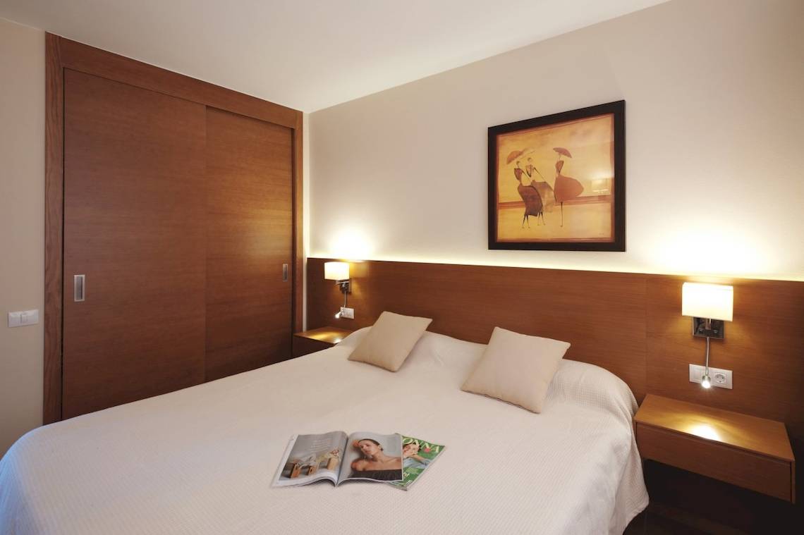 Hotelzimmer im Sotavento Beach Club mit Bett, Zeitschriften und Wanddekoration.