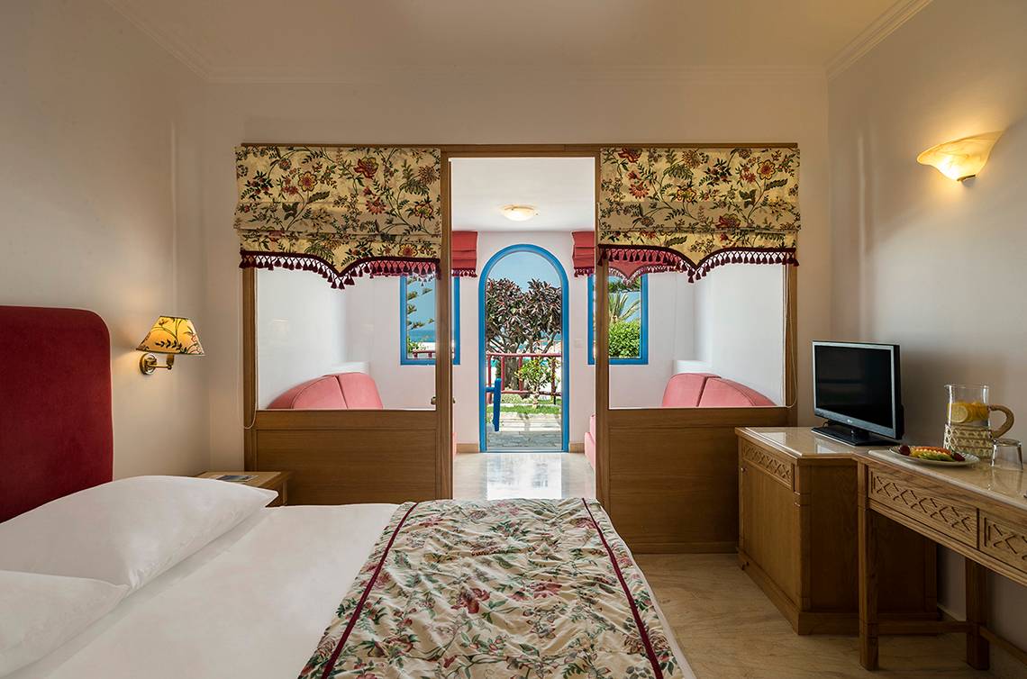 Zimmer im Mitsis Rinela Beach Hotel mit Bett und Balkon