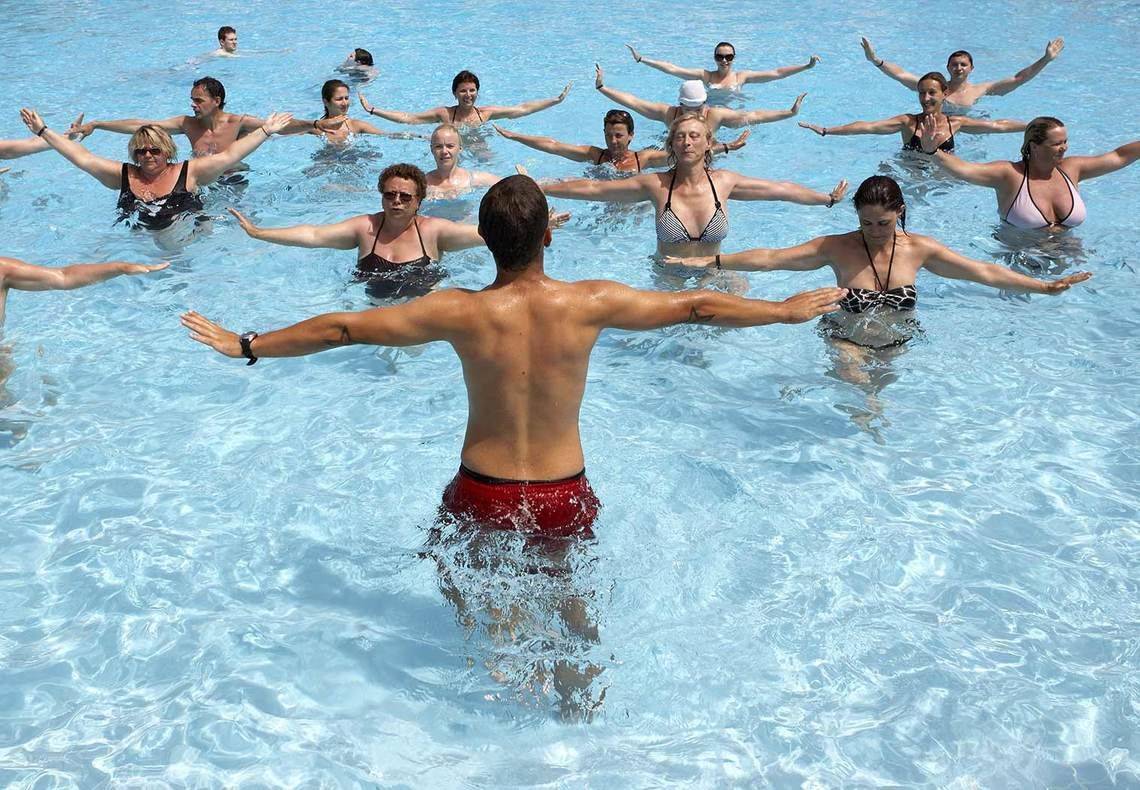 Gruppe von Schwimmern, die Wassergymnastik im Pool des Mitsis Rinela Beach Hotels machen.
