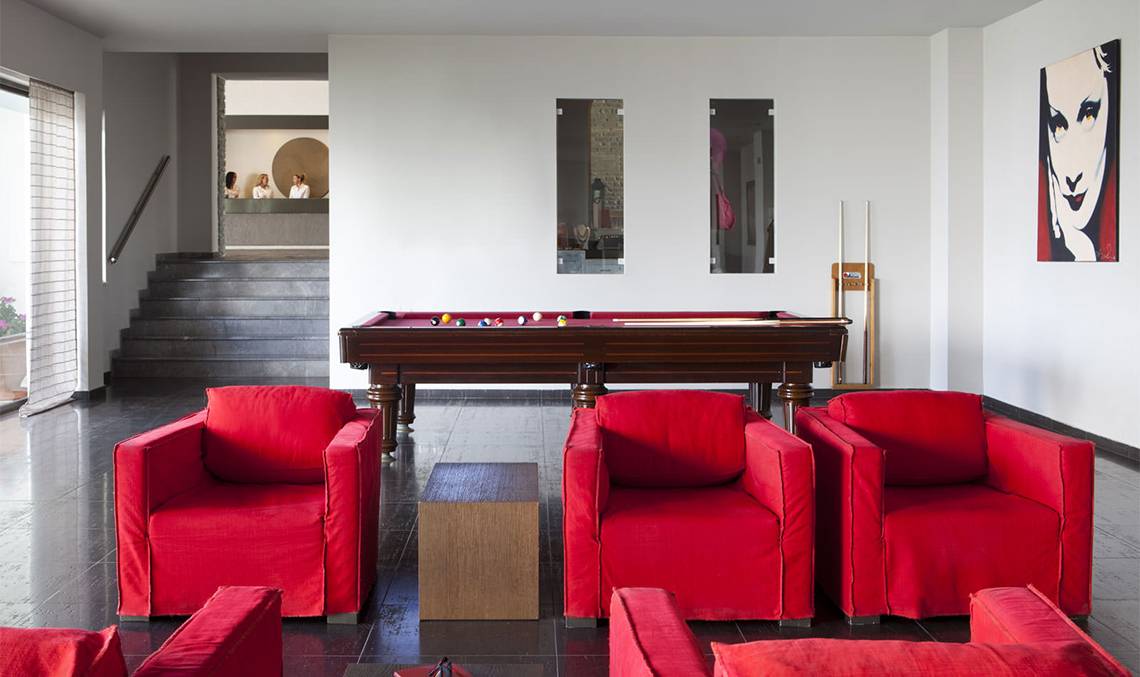 Minos Palace Hotel & Suites Lobby mit Pooltisch und roten Stühlen