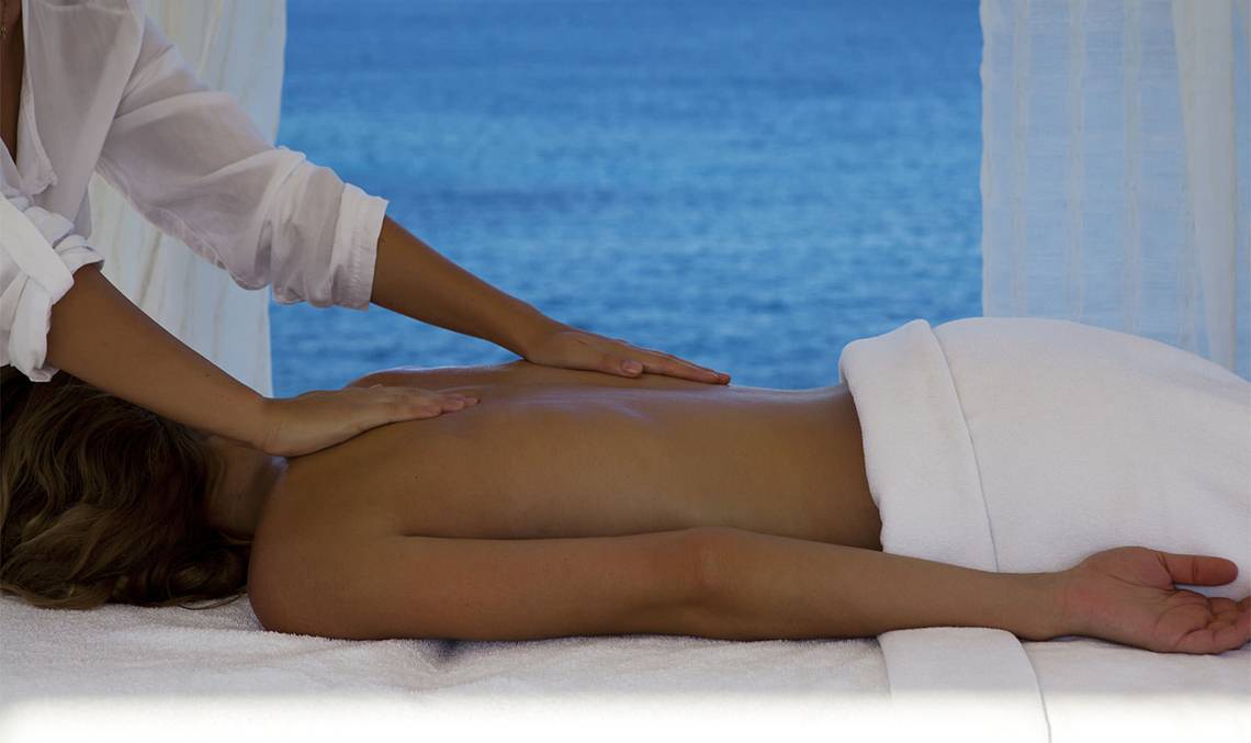 Eine Person erhält eine Massage im Minos Palace Hotel mit Blick auf das Meer.