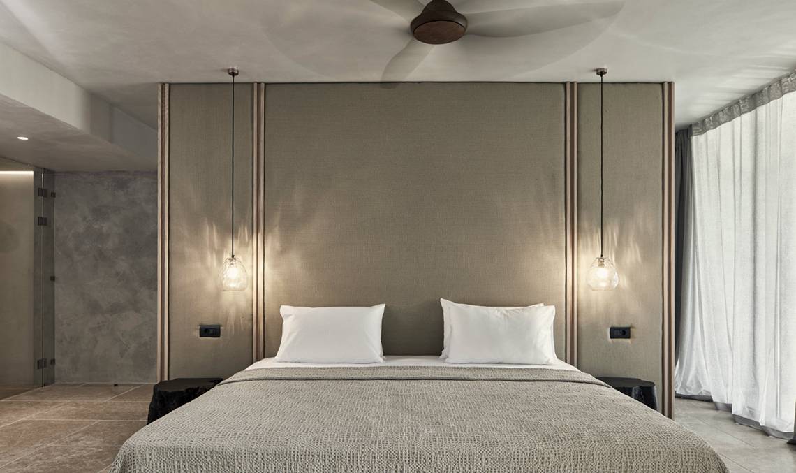 Schlafzimmer im Minos Palace Hotel & Suites mit zwei weißen Kissen und einer Bettdecke.