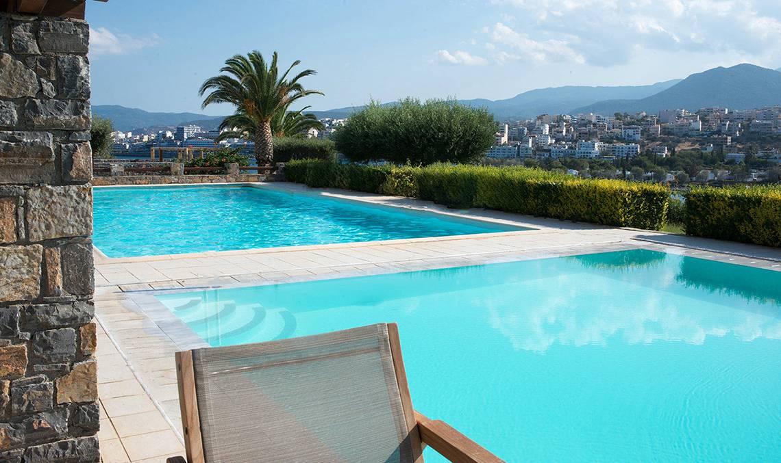 Außenpool des Minos Palace Hotel & Suites mit Blick auf die Stadt und Berge