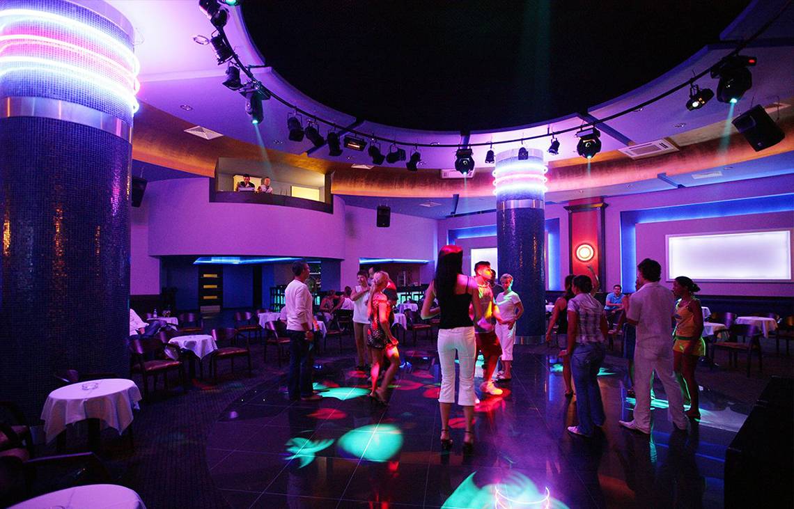 Disco-Saal im Side Sun Hotel mit bunten Lichtern und tanzenden Gästen.