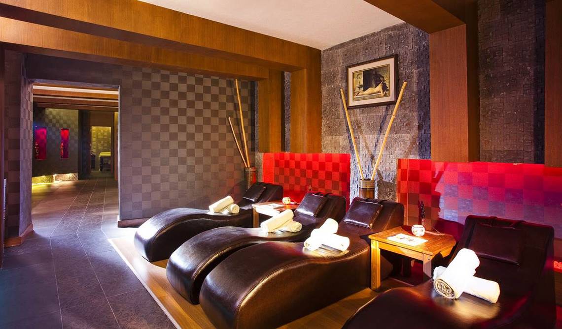 Massage-Lounge im Side Sun Hotel mit roten Wänden und Lederliegen.