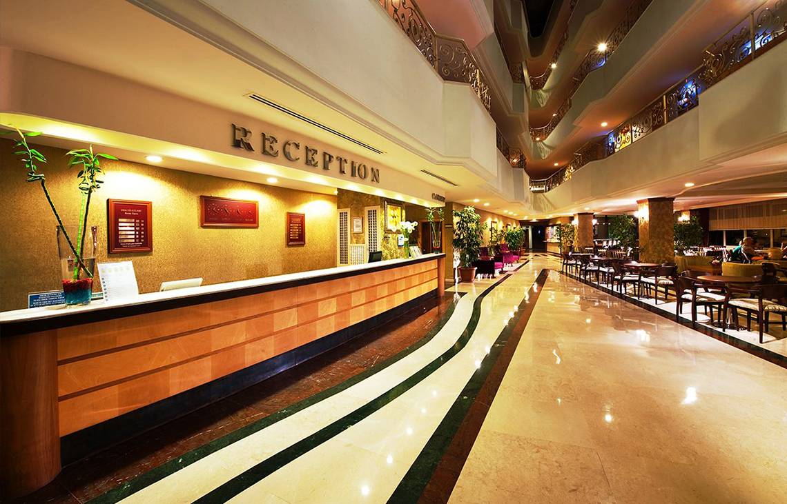 Foto von der Rezeption des Side Sun Hotels mit einer langen Marmortreppe und einem Empfangstresen.