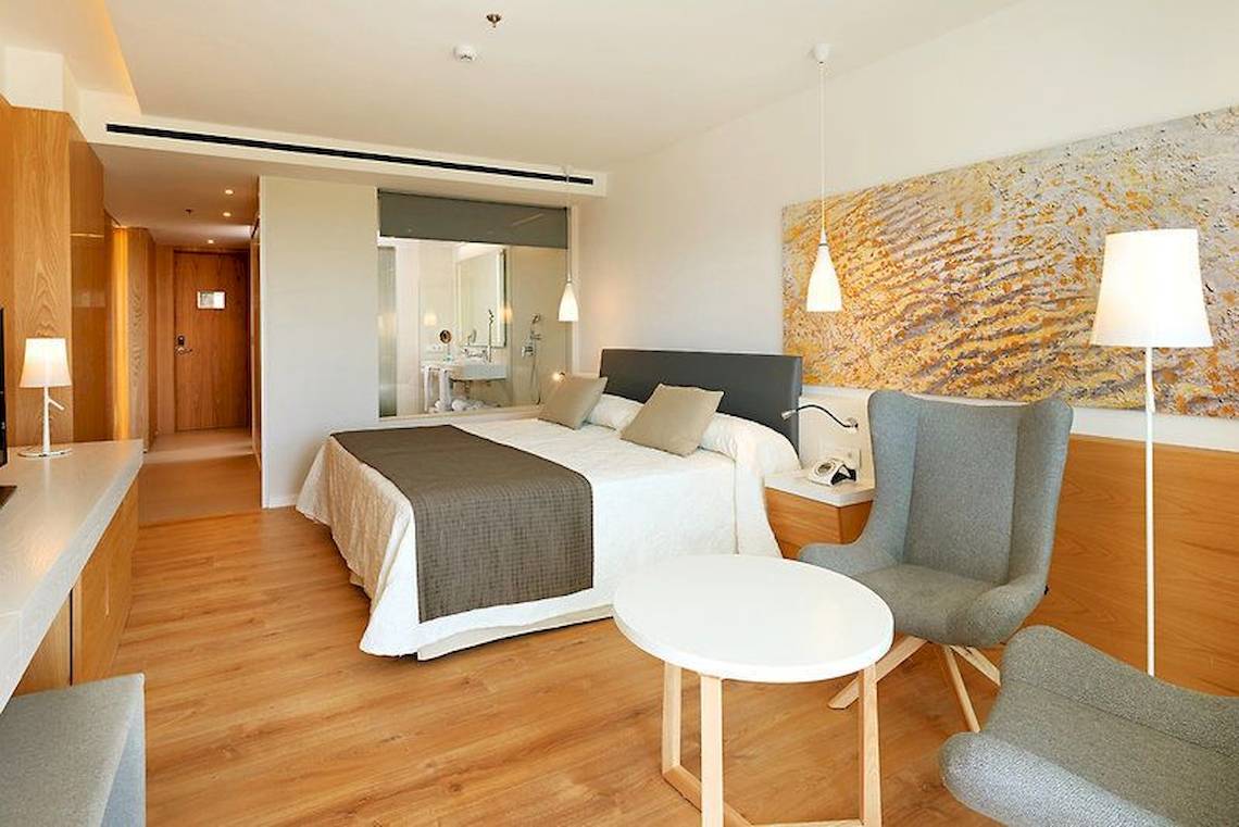 Hotelzimmer im Hipotels Playa de Palma Palace mit Doppelbett, Schreibtisch und Stühle.