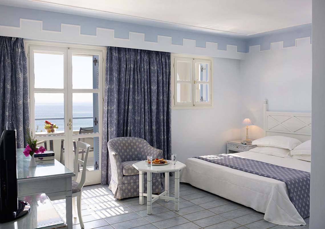 Zimmer im Mitsis Summer Palace Beach Hotel mit Meerblick, Bett, Tisch, Stuhl und Balkon