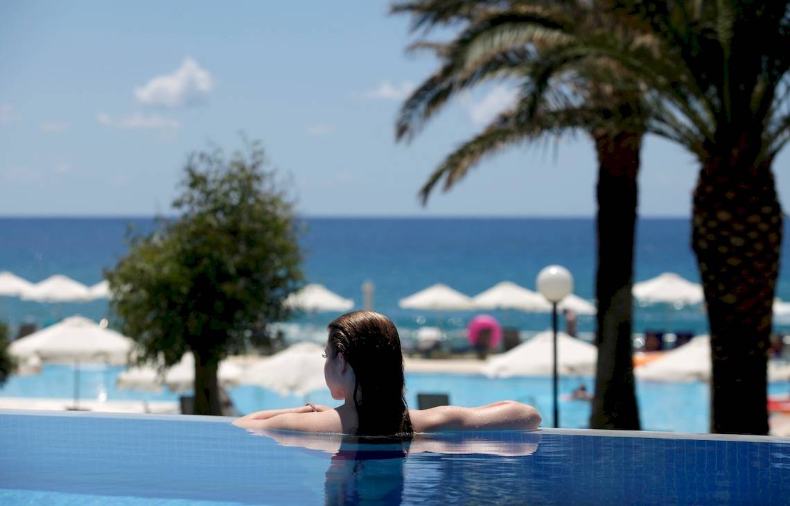 Frau am Poolrand des Domes of Corfu, Autograph Collection mit Blick auf das Meer