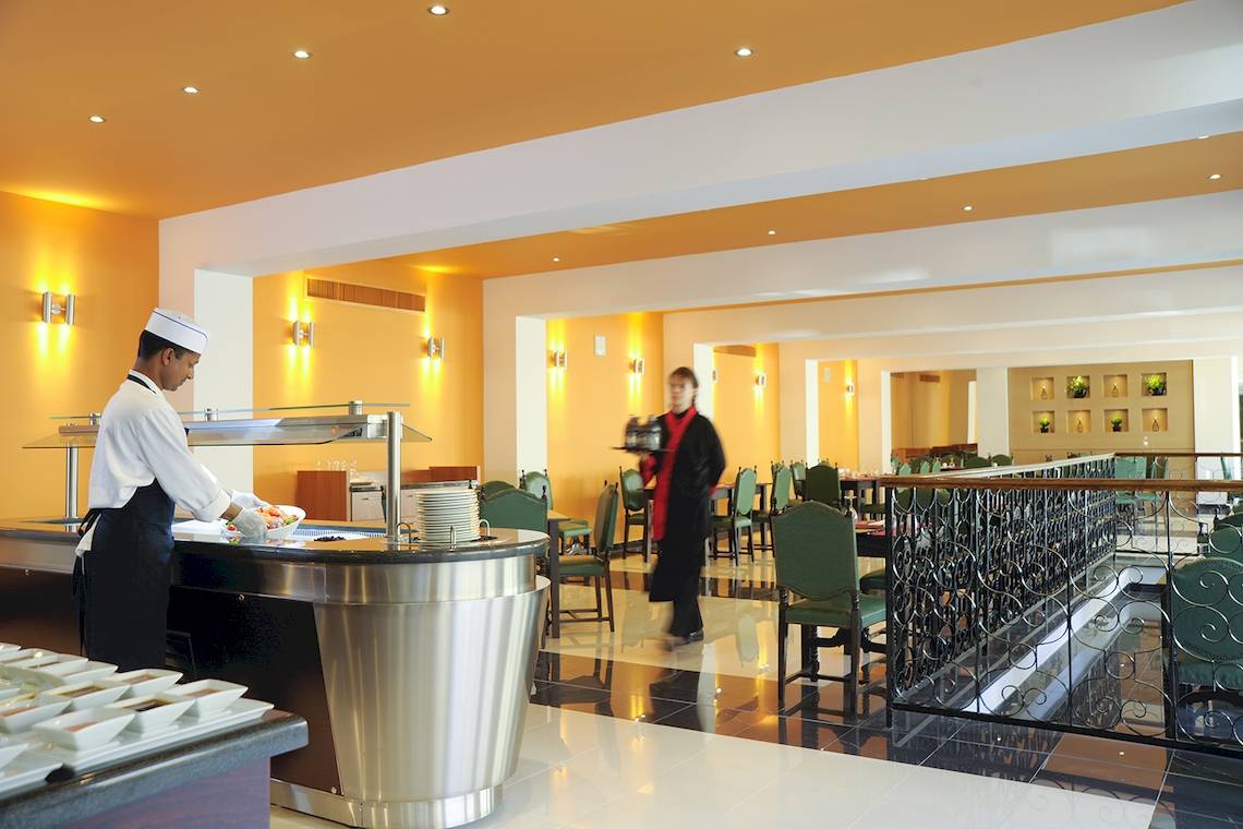 Ein Kellner serviert Essen in der Speisehalle des Domes of Corfu, Autograph Collection Hotel.