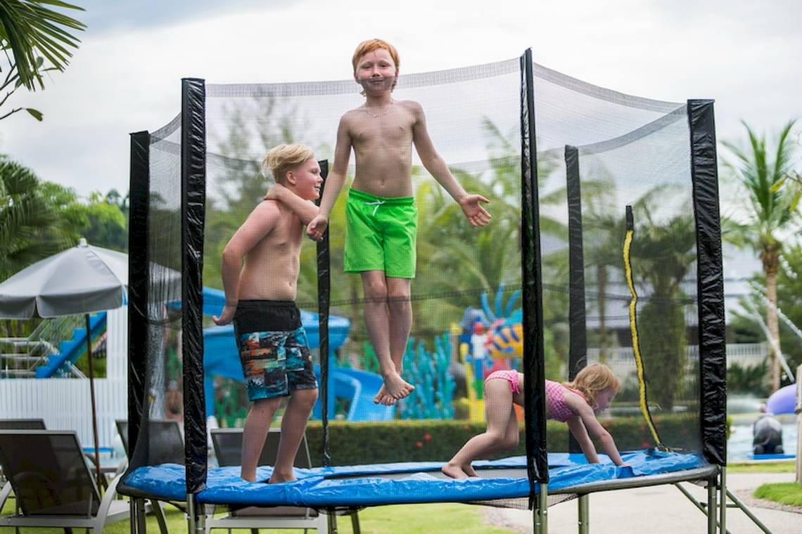 Kinder spielen auf einem Trampoline im Khao Lak Emerald Beach Resort & Spa.
