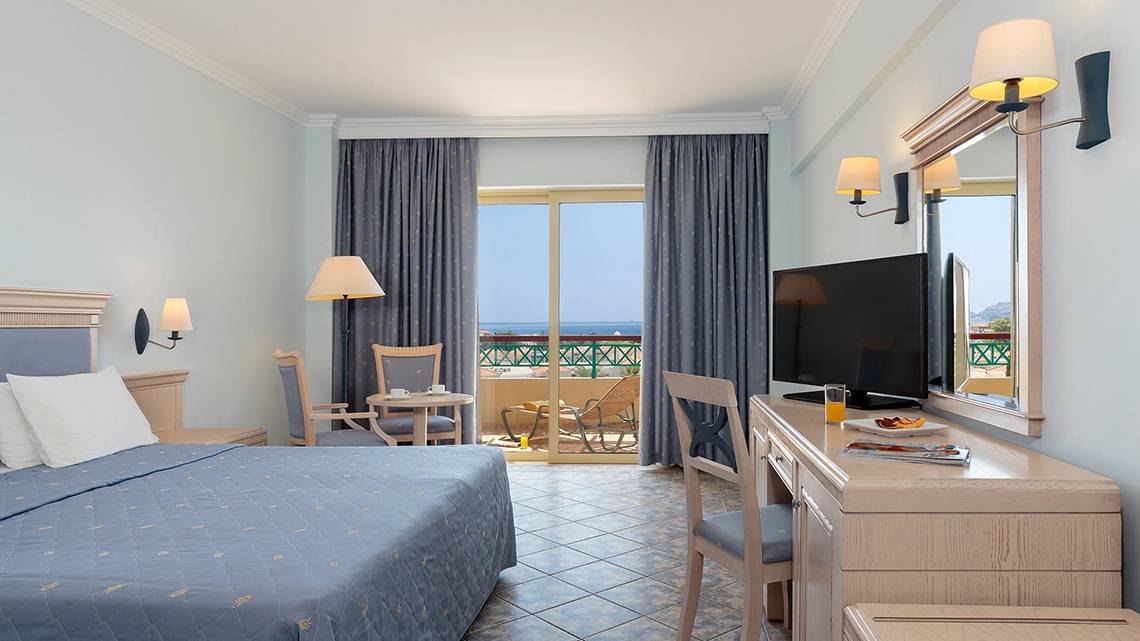 Hotelzimmer im Lindos Princess Beach Hotel mit Meerblick, Fernseher, Schreibtisch und Balkon.