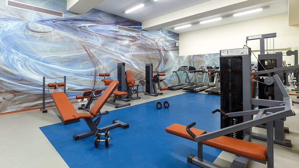 Fitnessbereich im Lindos Princess Beach Hotel mit Geräten und einer blauen Trainingsfläche.