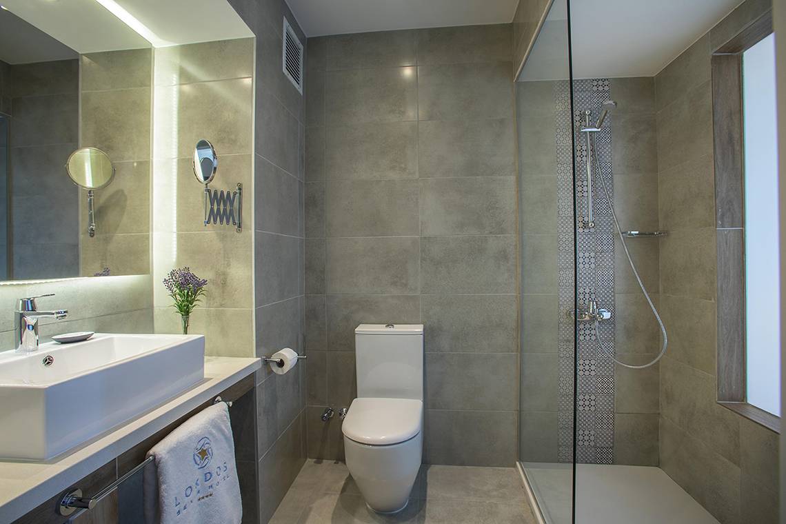 Badezimmer im Lordos Beach Hotel mit Dusche, Toilette und Waschbecken.