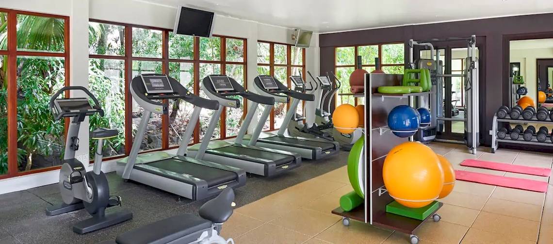 Fitnessstudio im Coco de Mer Hotel mit mehreren Laufbändern und diversen Trainingsgeräten.