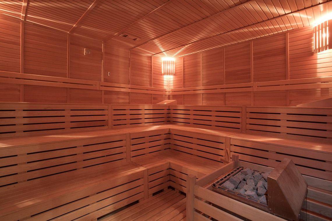 Innenansicht der Holzsauna im Side Orange Palace Hotel mit Holzbänken und Beleuchtung.