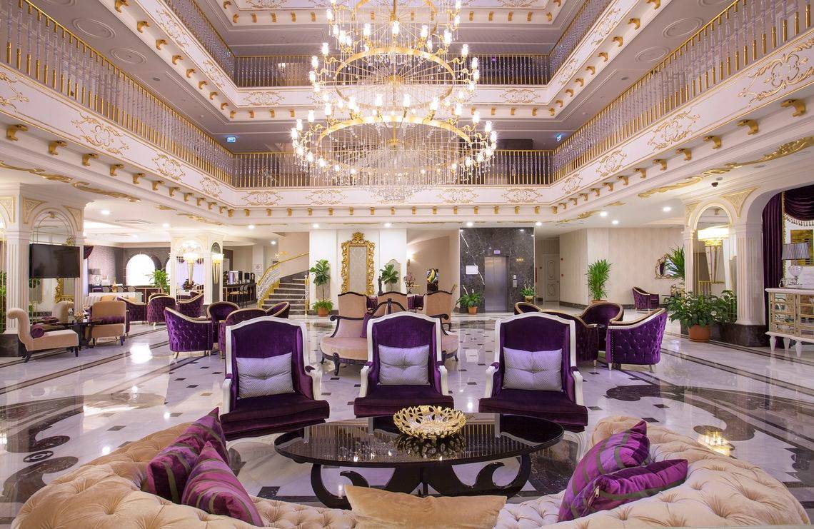 Innenbereich des Side Orange Palace Hotels mit luxuriösen Möbeln und einer großen Kristallleuchte.