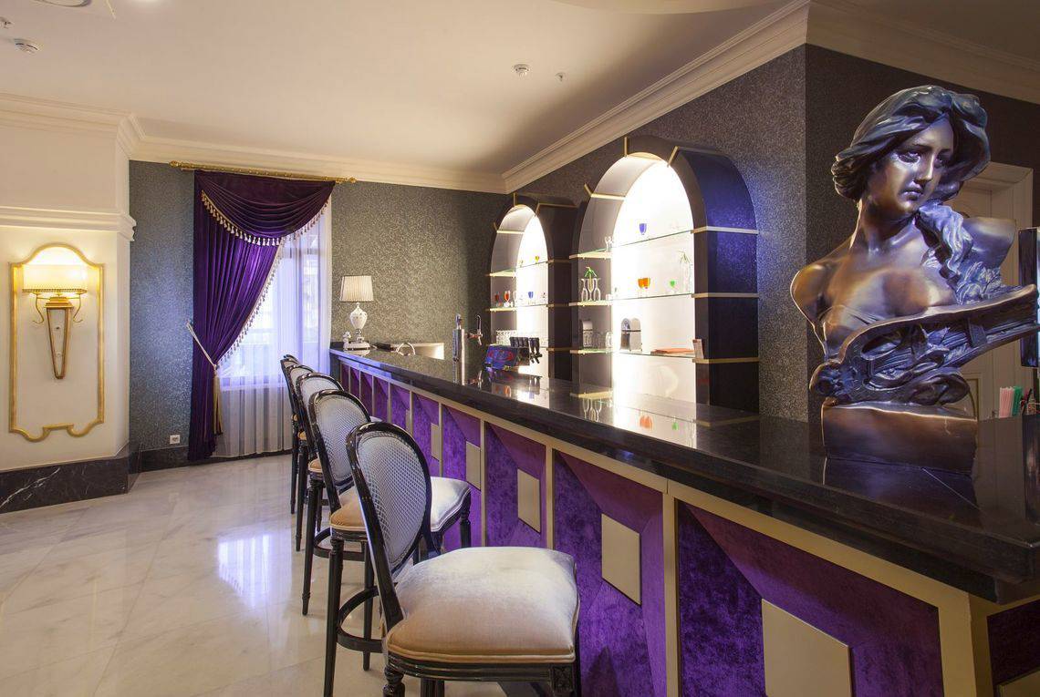Innenansicht der Bar im Side Orange Palace Hotel mit Marmortheke, Stühlen und Statue.
