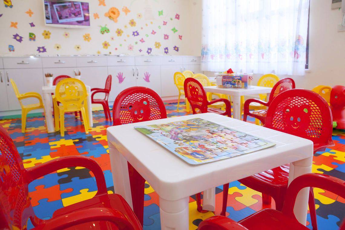Kinderzimmer im Side Orange Palace Hotel mit bunten Stühlen und Puzzle auf dem Tisch.