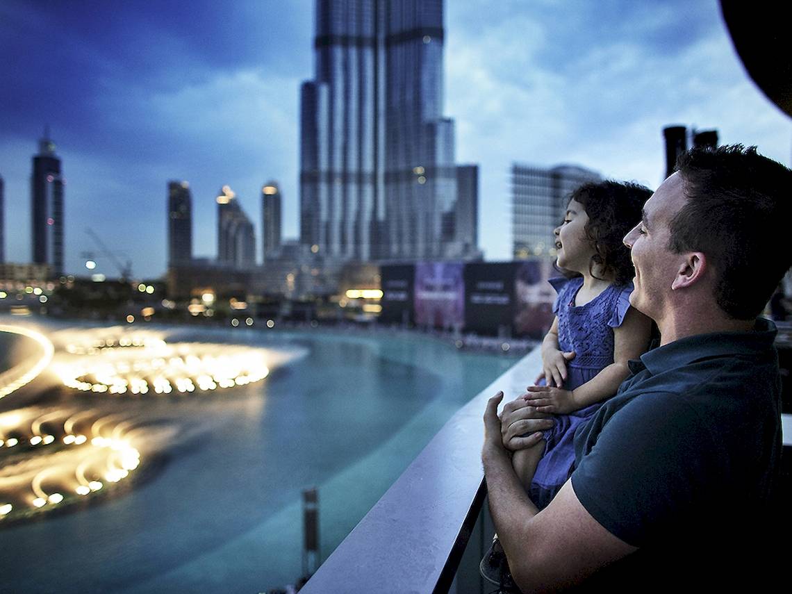 Vater und Tochter betrachten die Skyline von Dubai vom Balkon des Sofitel Dubai The Palm aus.