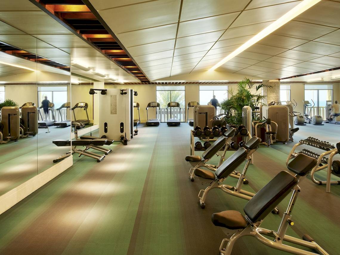 Fitnesscenter im Sofitel Dubai The Palm mit verschiedenen Trainingsgeräten und Spiegeln.