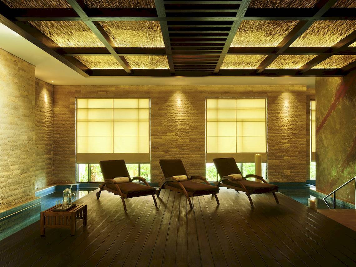 Innenbereich der Lounge im Sofitel Dubai The Palm mit drei Liegestühlen und einem Tisch