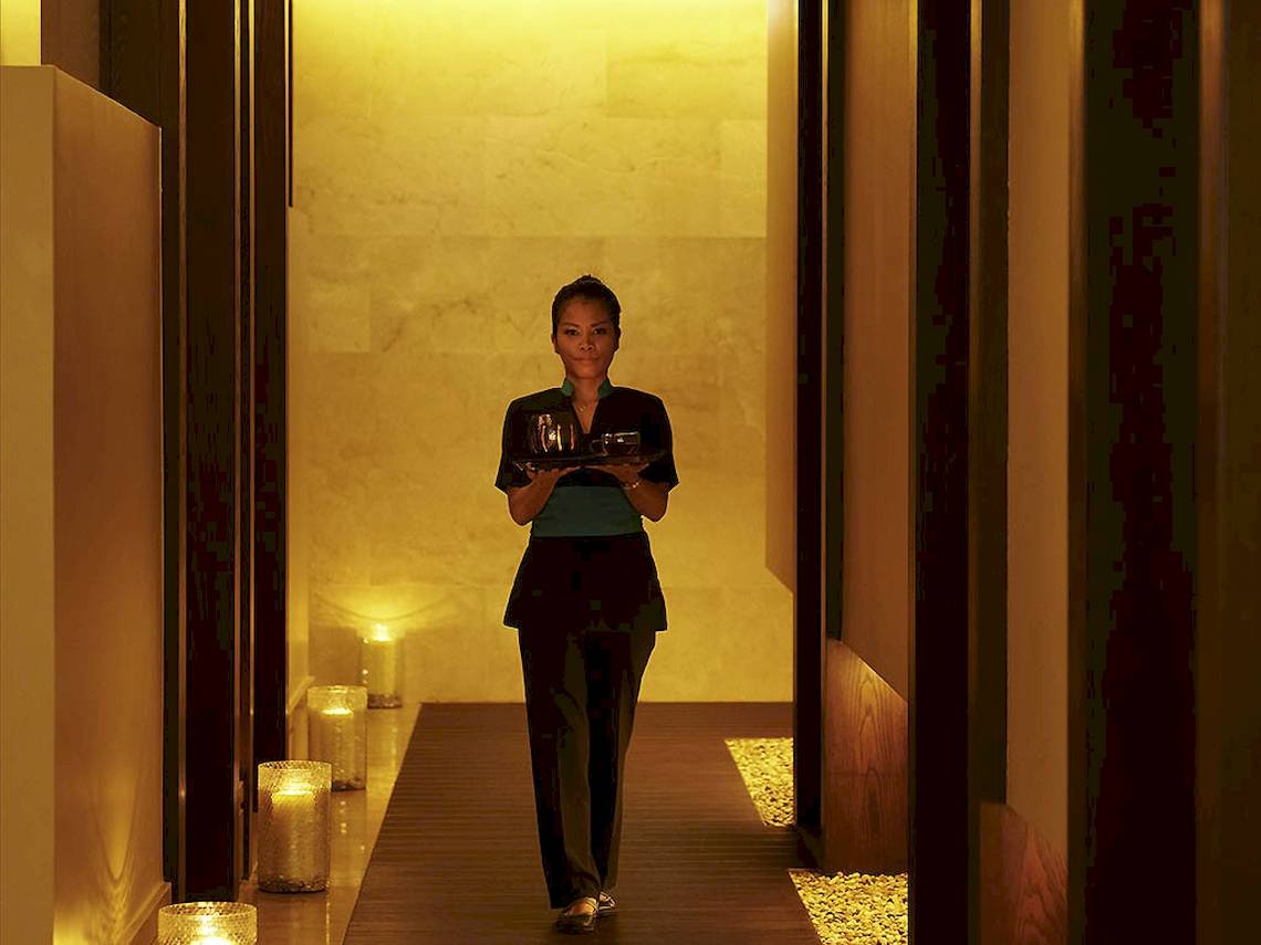Mitarbeiterin des Sofitel Dubai The Palm Hotels mit Tablett in einem leuchtenden Gang