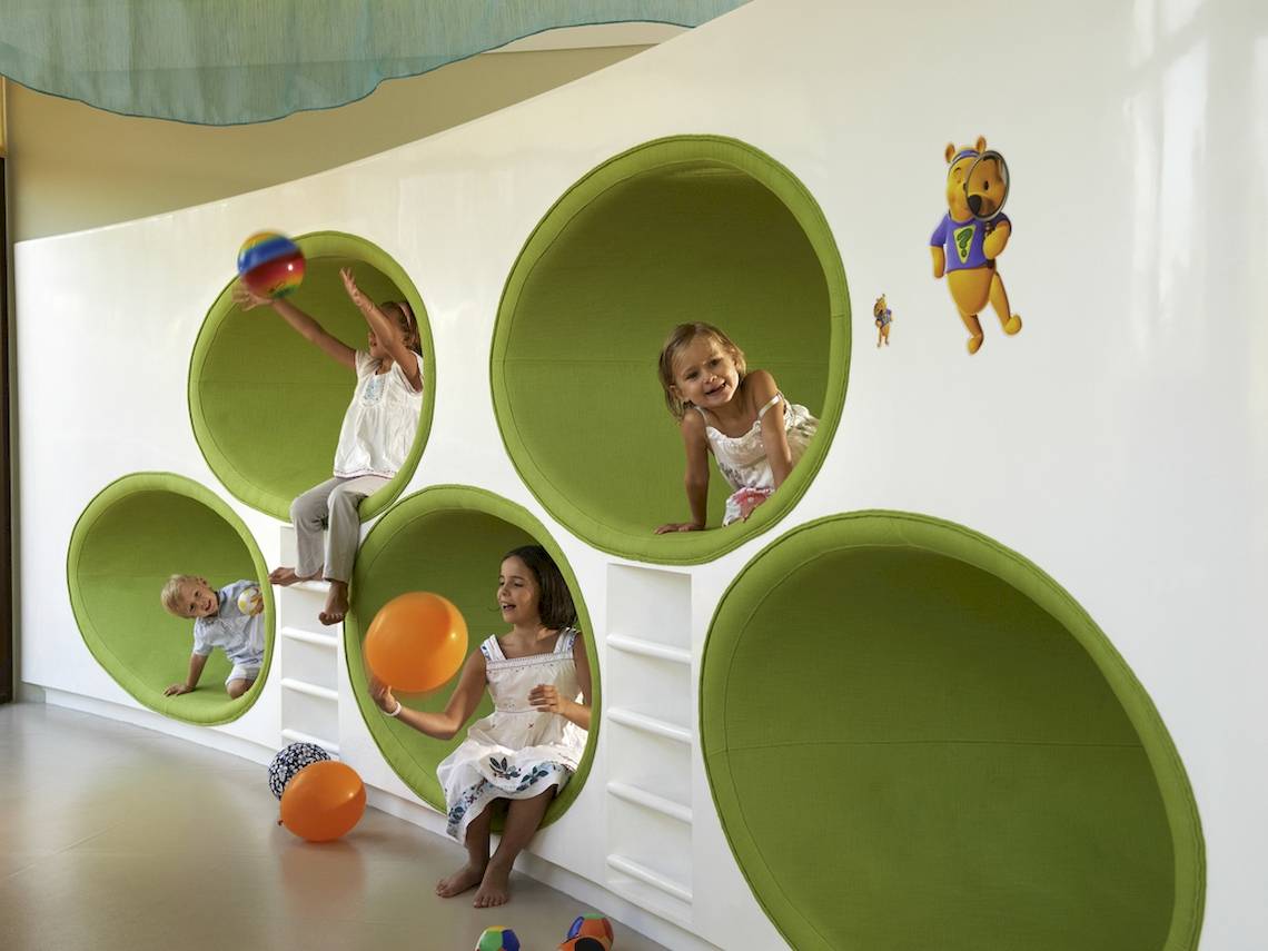 Kinder spielen in einem grünen, runden Spielzimmer im Sofitel Dubai The Palm.