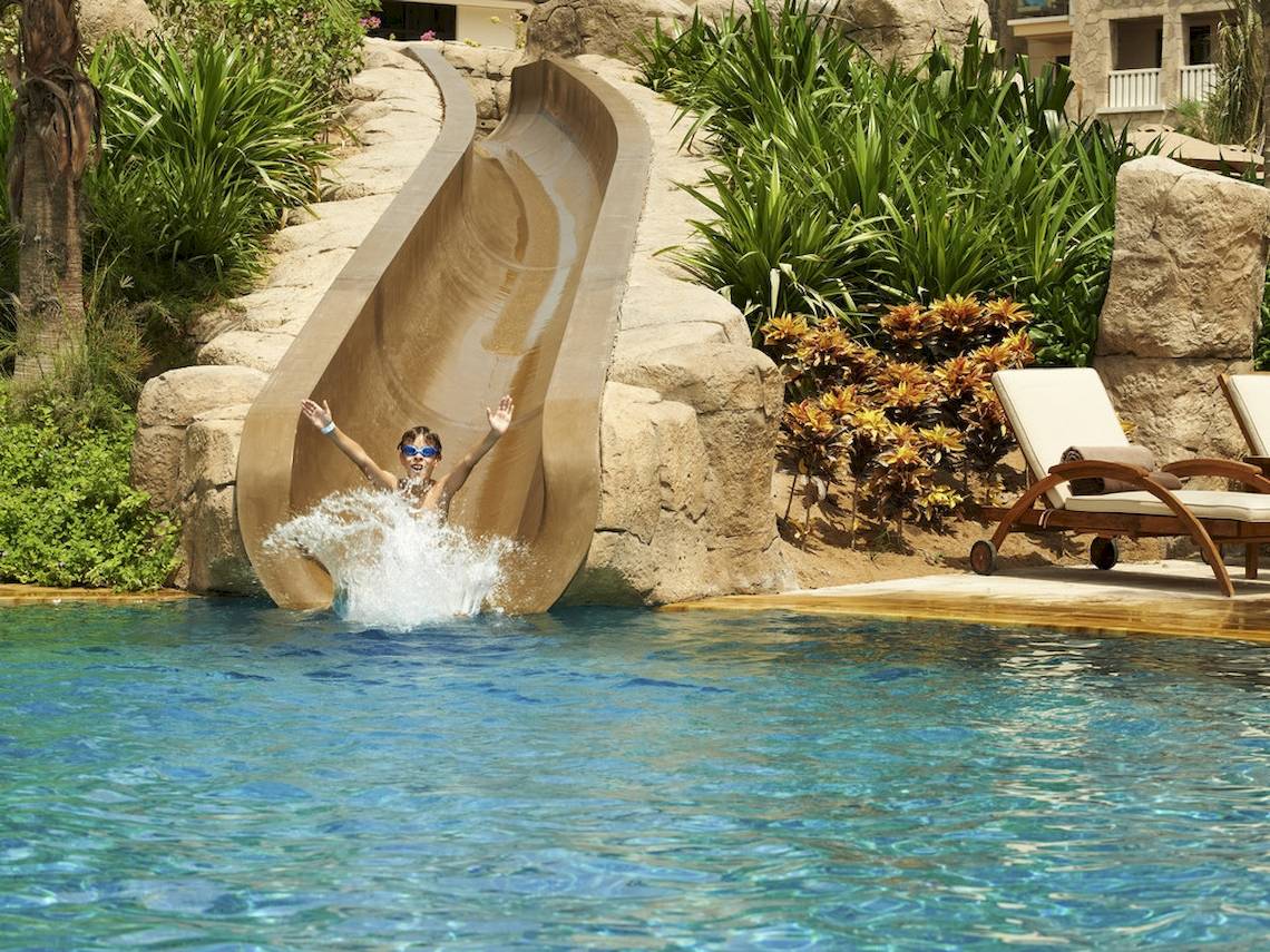 Ein Kind rutscht von einer Wasserrutsche in den Pool im Sofitel Dubai The Palm.