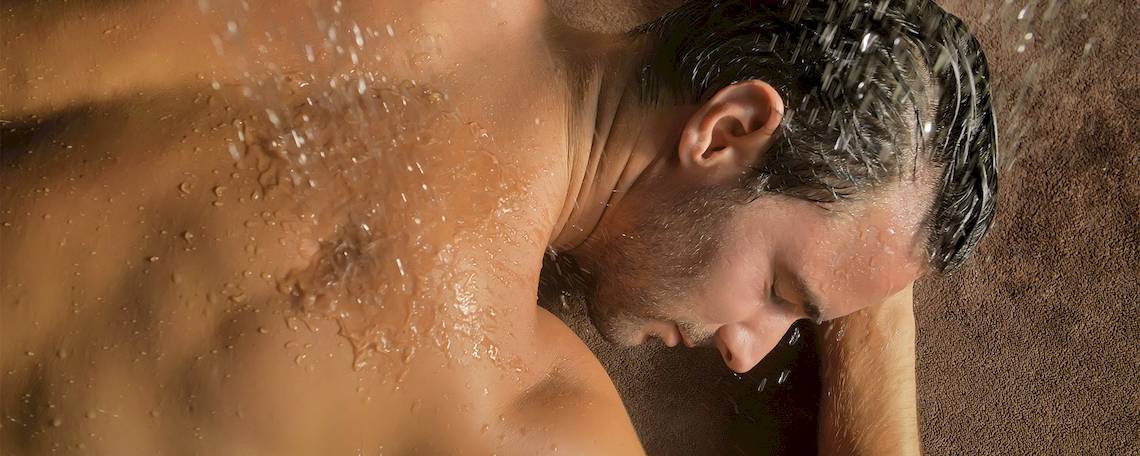 Mann duscht in der Dusche im Trou aux Biches Beachcomber Golf Resort & Spa