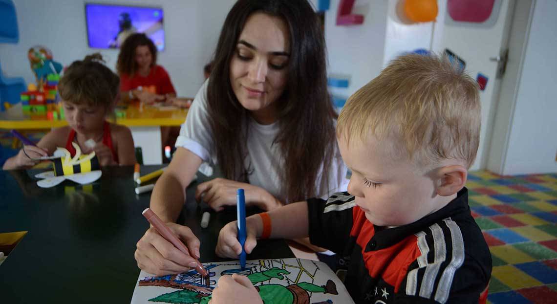 Eine Frau und ein kleiner Junge malen ein Bild im Pickalbatros White Beach Resort Kinderzimmer.