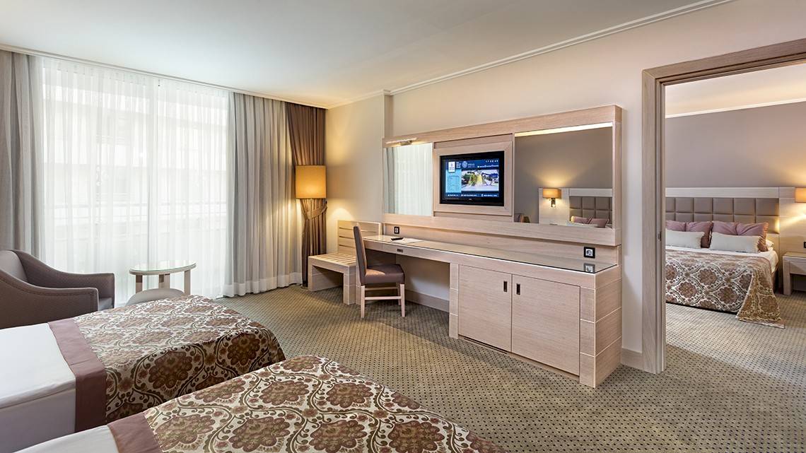Doppelzimmer mit Arbeitsbereich, Fernseher, Schreibtisch und zwei Betten im Miracle Resort.