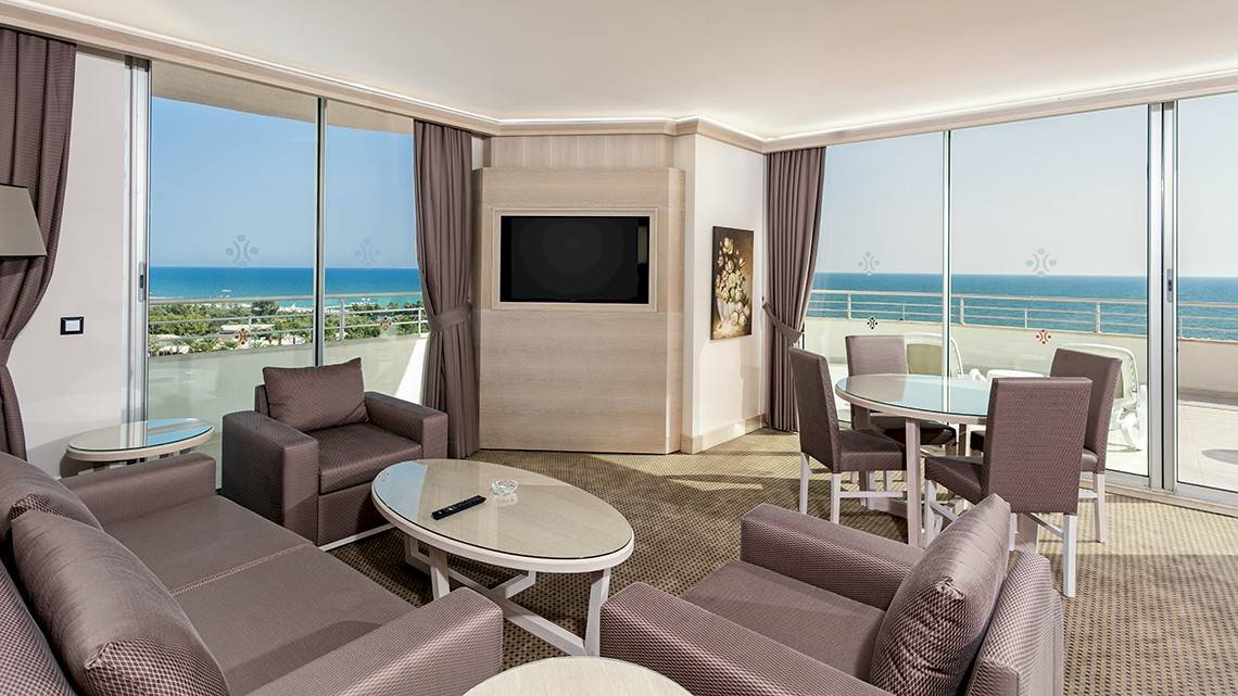 Suite mit Meerblick im Miracle Resort, inklusive Wohnzimmer, Schlafbereich und Balkon.
