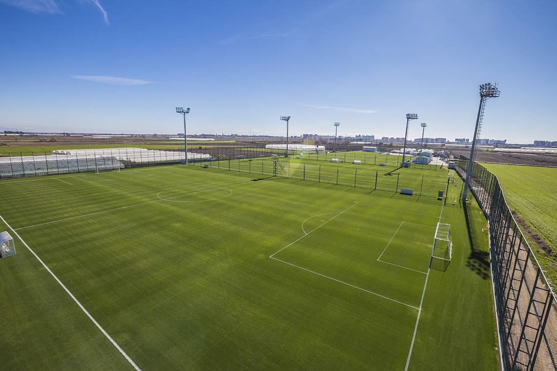 Luftaufnahme eines leeren Fußballfeldes im Miracle Resort mit grünem Rasen und weißen Linien.