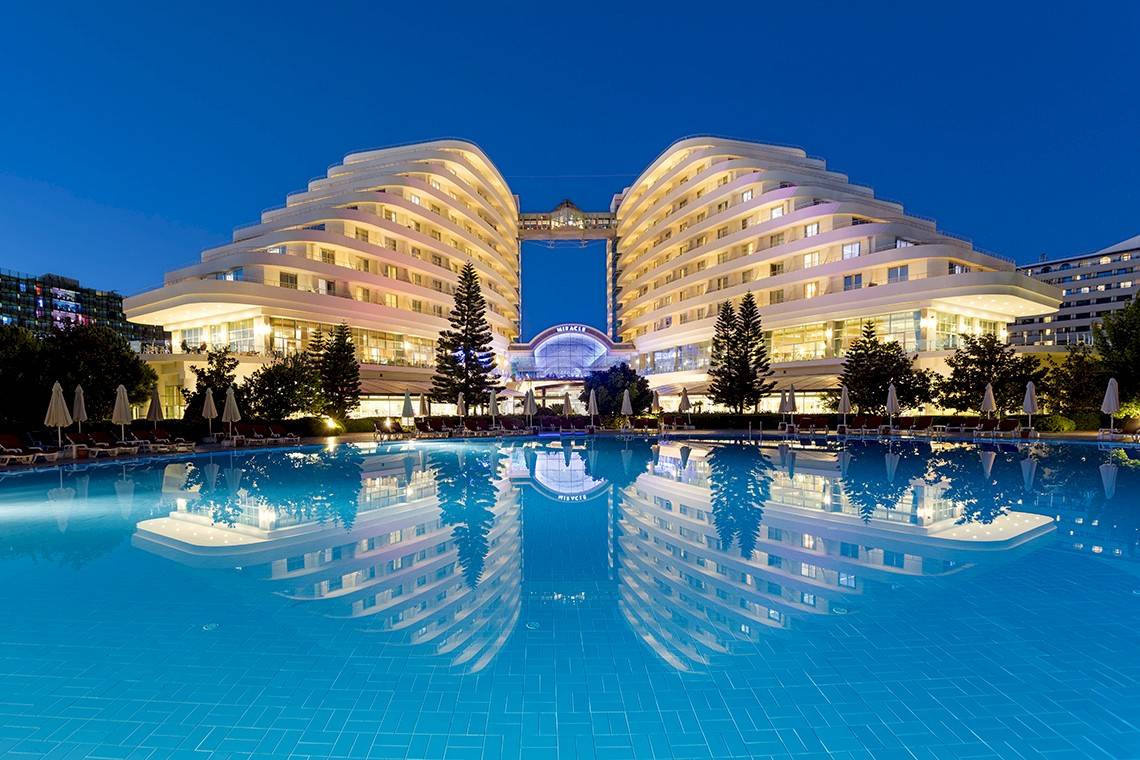 Miracle Resort im Abendlicht mit Swimmingpool und Hotelreflektion