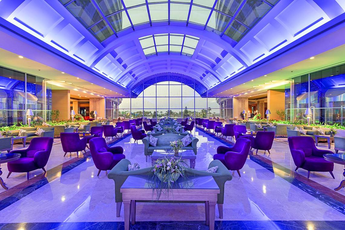 Innenansicht der Lobby im Miracle Resort mit violetten Stühlen und Tischen.