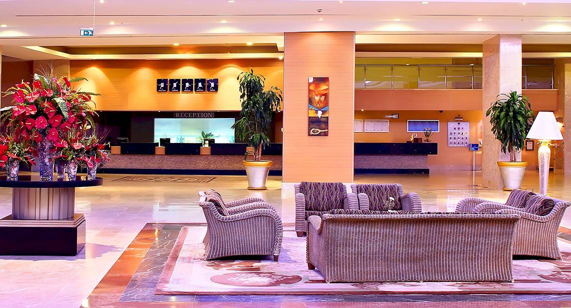 Empfangsbereich des Miracle Resort Hotels mit Blumen, Pflanzen und Sitzmöbeln