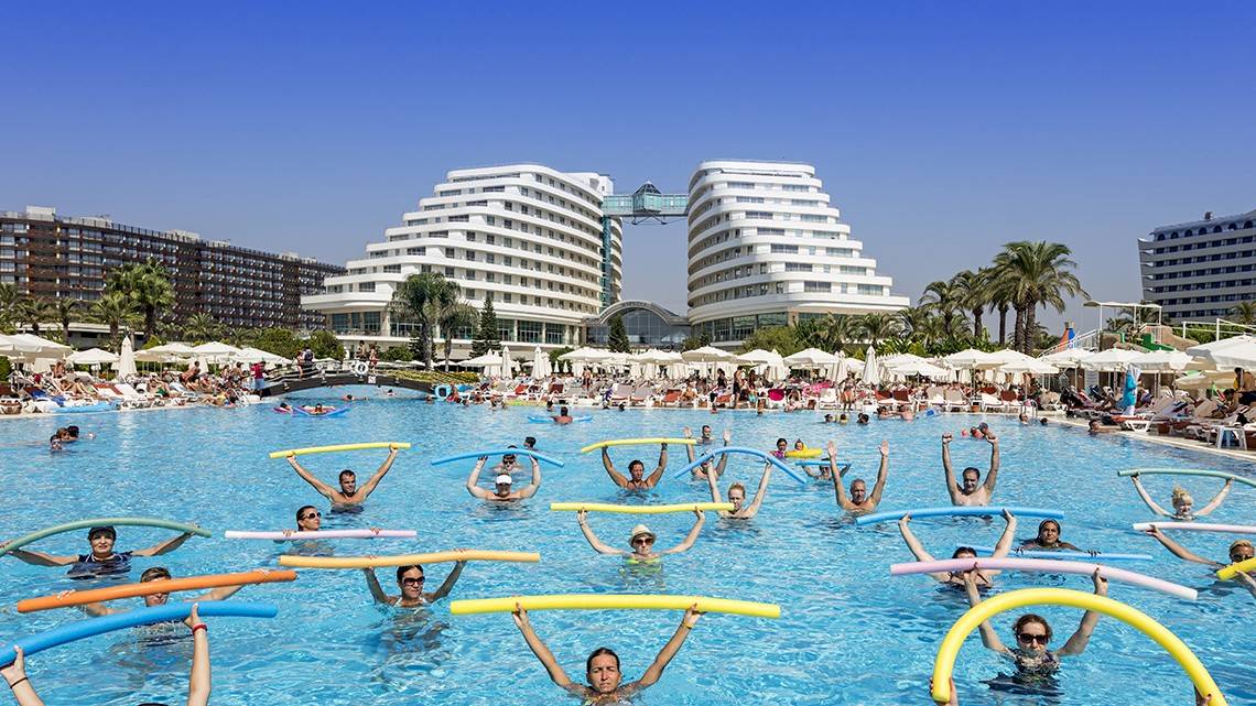 Gruppe von Leuten, die Aqua-Fitness im Miracle Resort machen, mit bunten Schwimmhilfen.