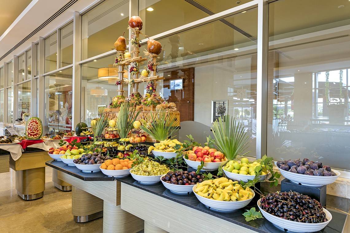 Wunderschönes Frühstücksbuffet im Miracle Resort mit einer Vielzahl von Obst in weißen Schalen.
