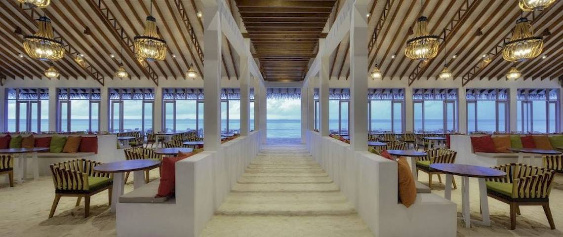 Innenbereich des OBLU Nature Helengeli Restaurants mit Blick auf das Meer und mehreren Tischen und Stühlen.