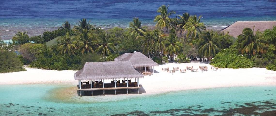 Luftaufnahme des OBLU NATURE Helengeli Resorts, zwei Hütten am Strand mit Tischen und Stühlen.