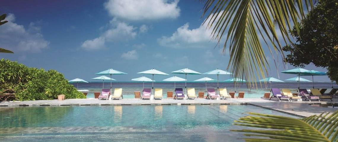 Außenbereich des OBLU NATURE Helengeli Hotels mit Pool, Lounge-Stühlen und Sonnenschirmen.