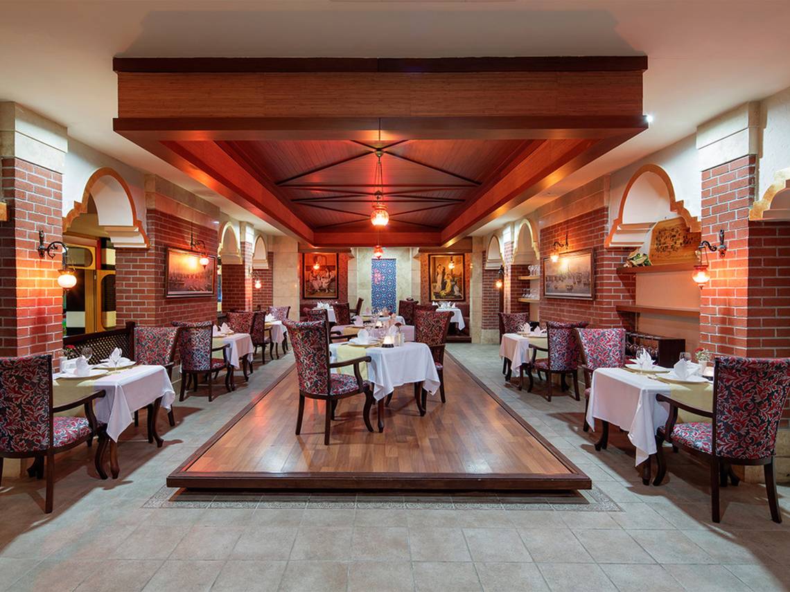 Innenbereich des Restaurants im Crystal Family Resort & Spa mit eingerichteten Tischen und Stühlen.