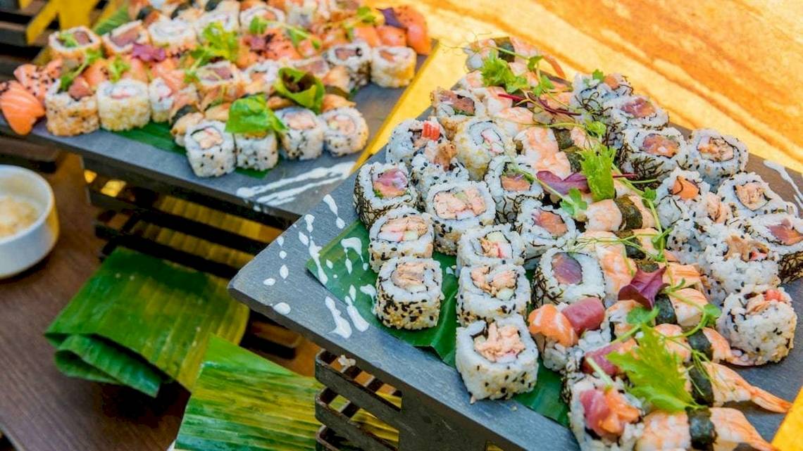 Sushi-Buffet im AX The Palace Hotel mit verschiedenen Sushi-Rollen auf schwarzen Platten.