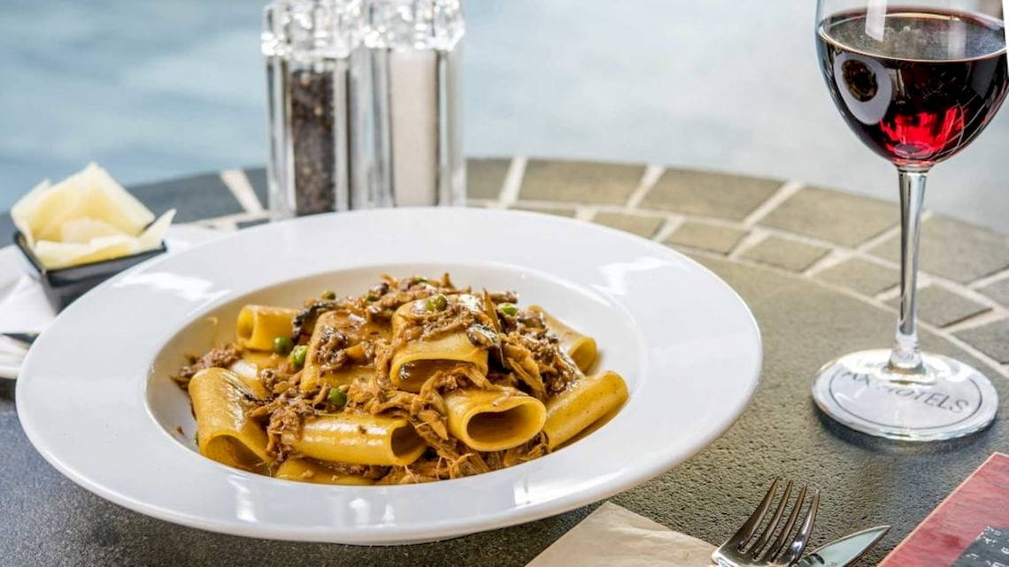 Ein Teller mit Penne in einer braunen Soße, serviert im AX The Palace Hotel.
