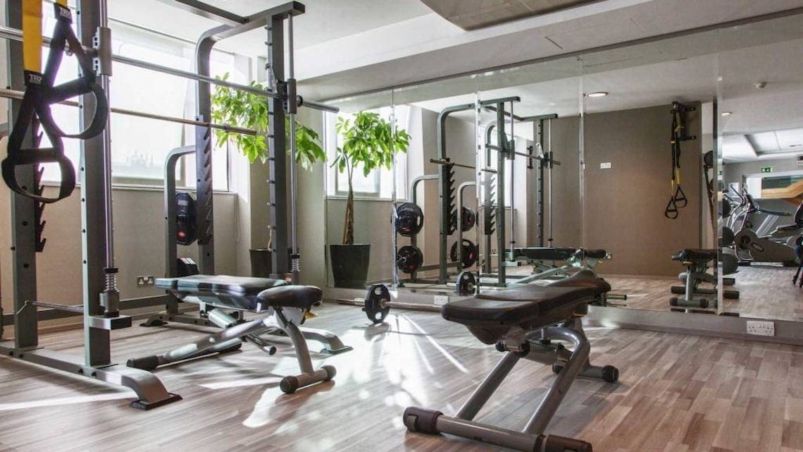 Fitnesscenter im AX The Palace Hotel mit verschiedenen Trainingsgeräten und Spiegeln.
