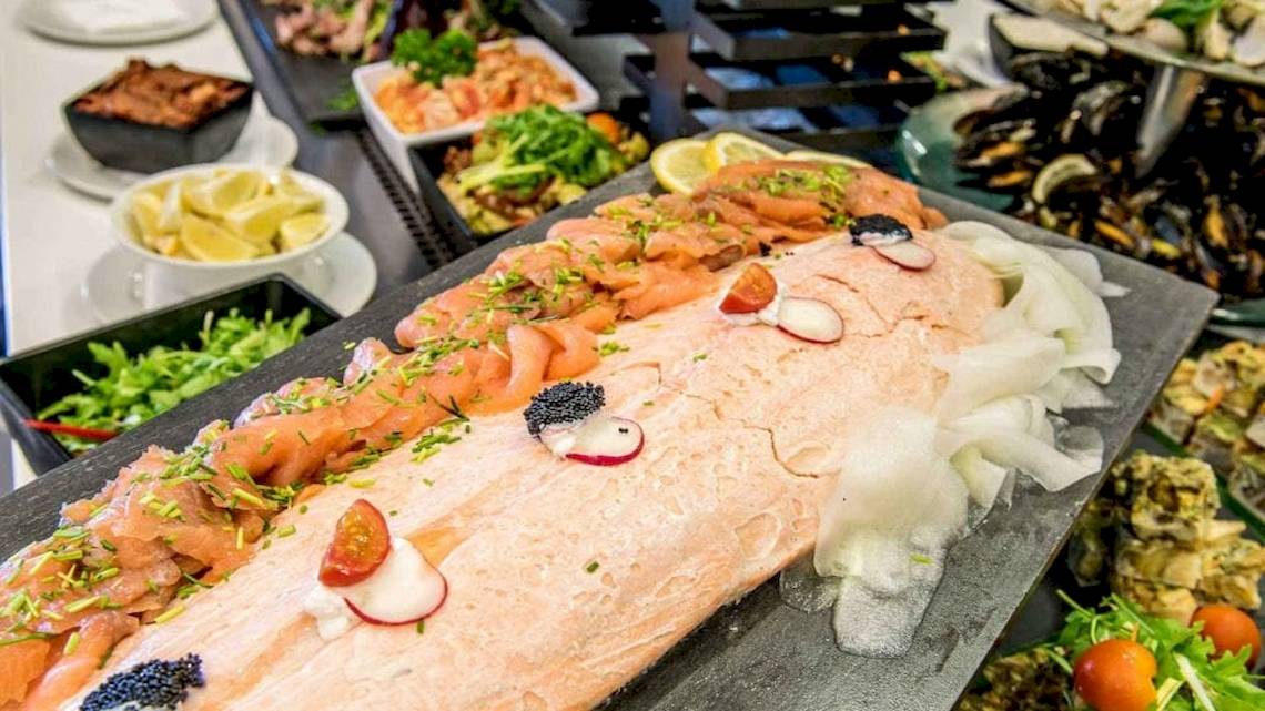 Buffet-Tisch im AX The Palace Hotel mit verschiedenen Gerichten, einschließlich Lachs und Beilagen.