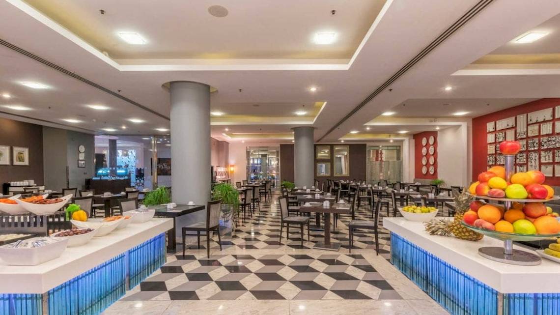 Frühstücksbuffet im AX The Palace Hotel mit Obst, Gemüse und verschiedenen Gerichten.
