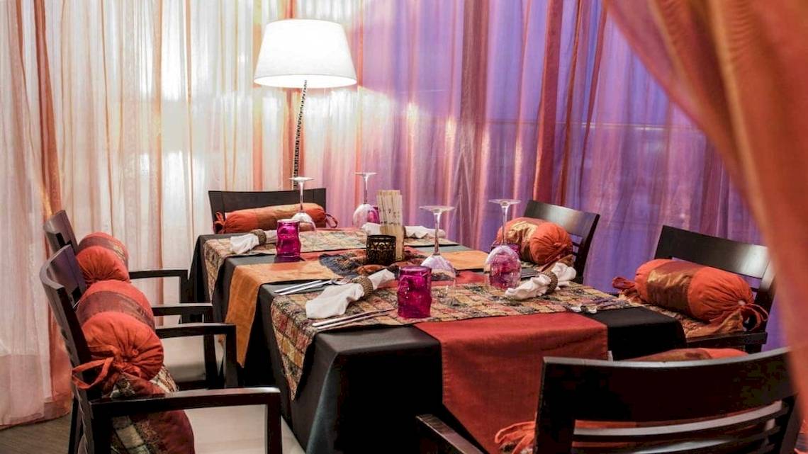 Das Esszimmer im AX The Palace Hotel mit Tisch, Stühlen und Tischdekoration.