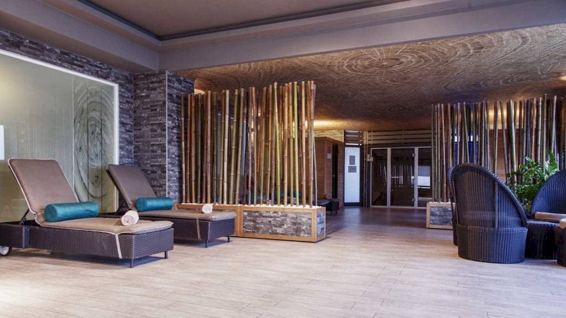 Loungebereich im AX The Palace Hotel mit Bambuswänden und modernen Möbeln.